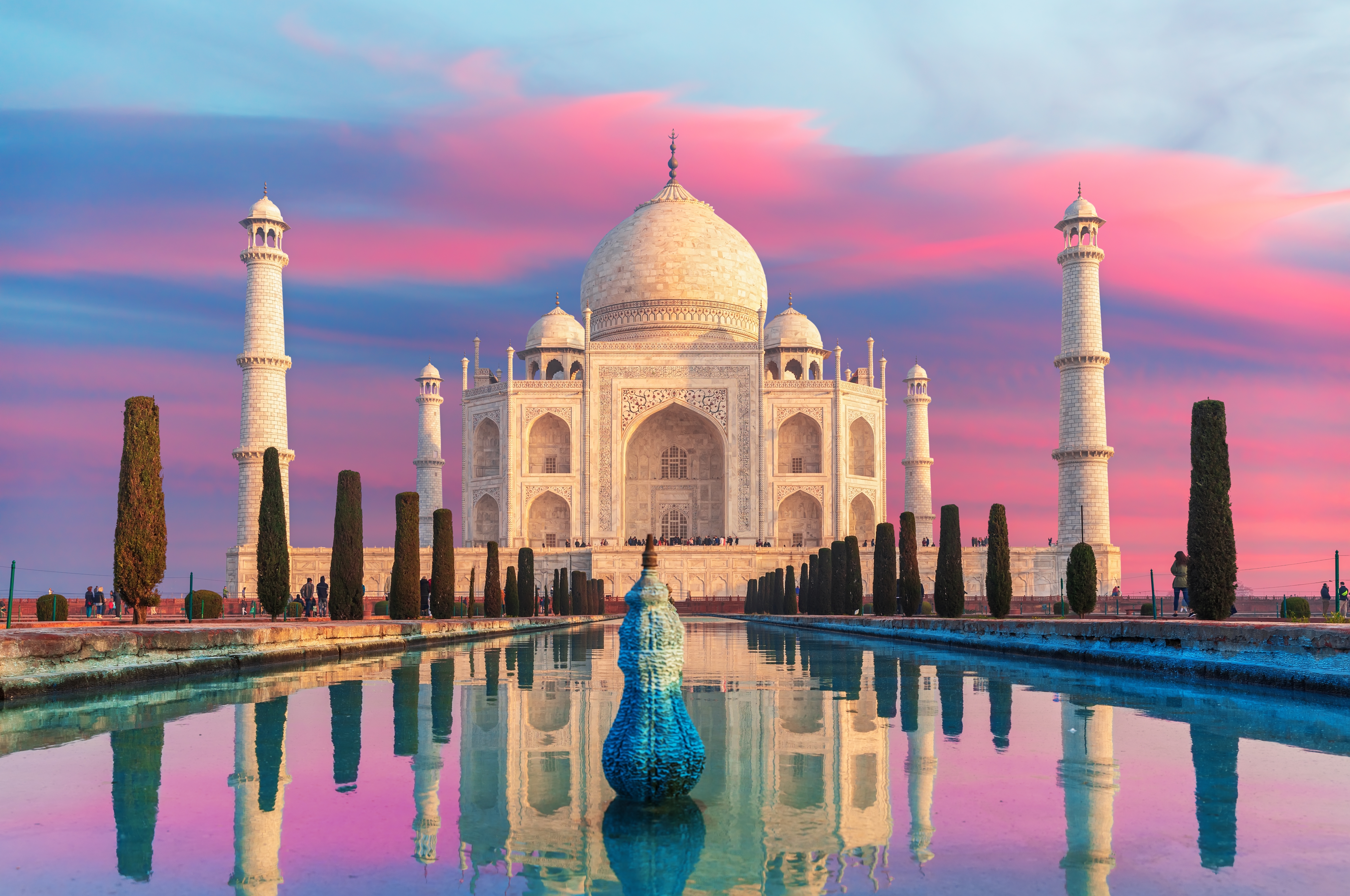 Taj Mahal i Agra ved solnedgang med smuk lyserød himmel og perfekt spejling i vandet, Indiens mest berømte marmormonument