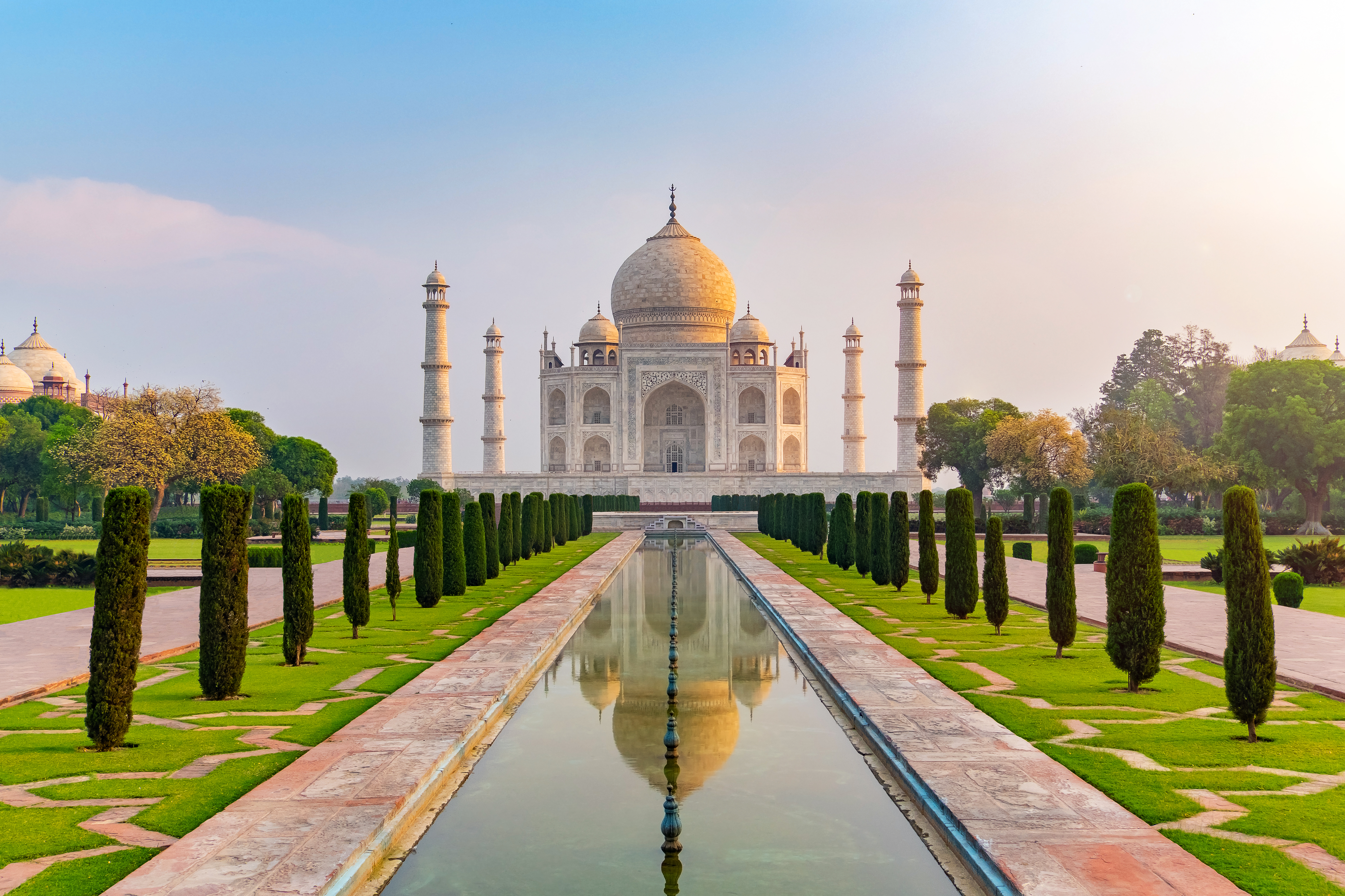 Taj Mahal i Agra, Indien, spejlet i den lange reflektionspool ved solopgang – et af verdens syv vidundere