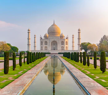 Taj Mahal i Agra, Indien, spejlet i den lange reflektionspool ved solopgang – et af verdens syv vidundere