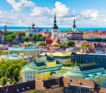 Betagende luftfoto af Tallinns historiske gamle bydel med middelalderarkitektur, farverige tage og tårne i sommerligt Estland