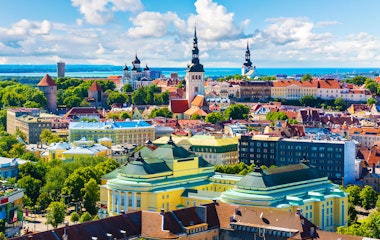 Betagende luftfoto af Tallinns historiske gamle bydel med middelalderarkitektur, farverige tage og tårne i sommerligt Estland