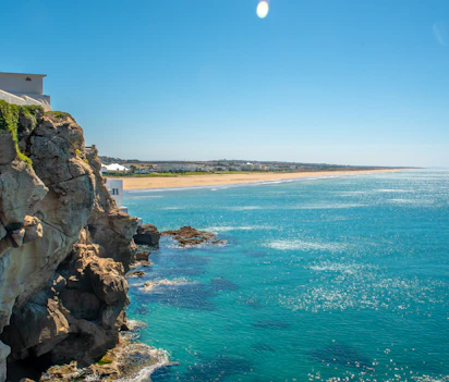 Betagende udsigt over kysten ved Tangier i Marokko med turkisblåt hav, gylden sandstrand og dramatiske klippeformationer