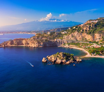Panoramaudsigt over Taormina med Etna-vulkanen i baggrunden, kystby på Sicilien med udsigt over Middelhavet