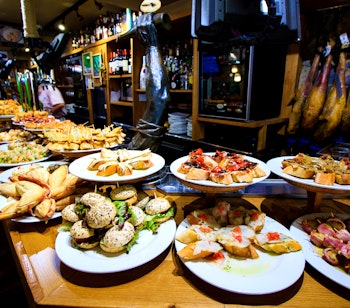 Farverige spanske tapas og pintxos på bardisken i en traditionel tapasbar i Zaragoza - en smagfuld oplevelse på vores gastronomiske vandring gennem byens historiske kvarterer