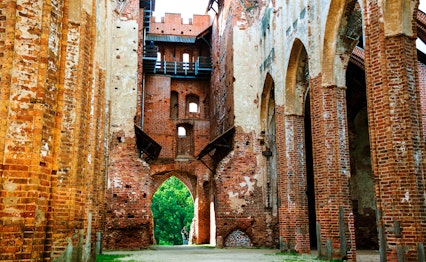 Imponerende ruiner af Dorpat Katedralen i Tartu med dens majestætiske gotiske arkitektur, røde mursten og historiske stenbuer - et fascinerende kulturmindesmærke i Estland