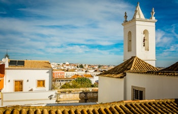 Historisk klokketårn og hvide bygninger med terrakottatage i Tavira, Algarve - en smuk udsigt over den portugisiske kystby