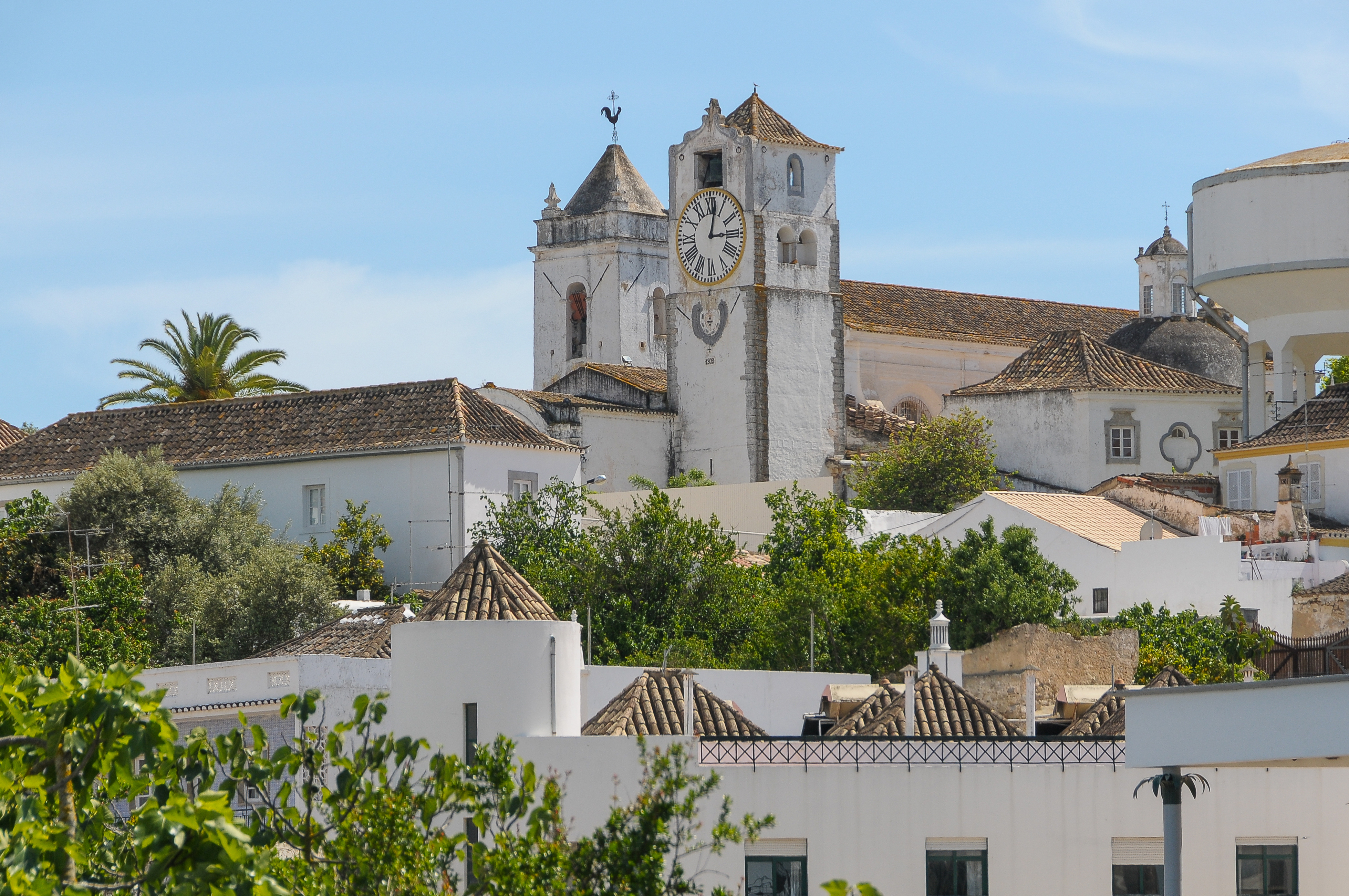 Udsigt over Taviras historiske bycentrum med klokketårnet fra Santa Maria do Castelo kirken i Algarve, Portugal under blå sommerhimmel