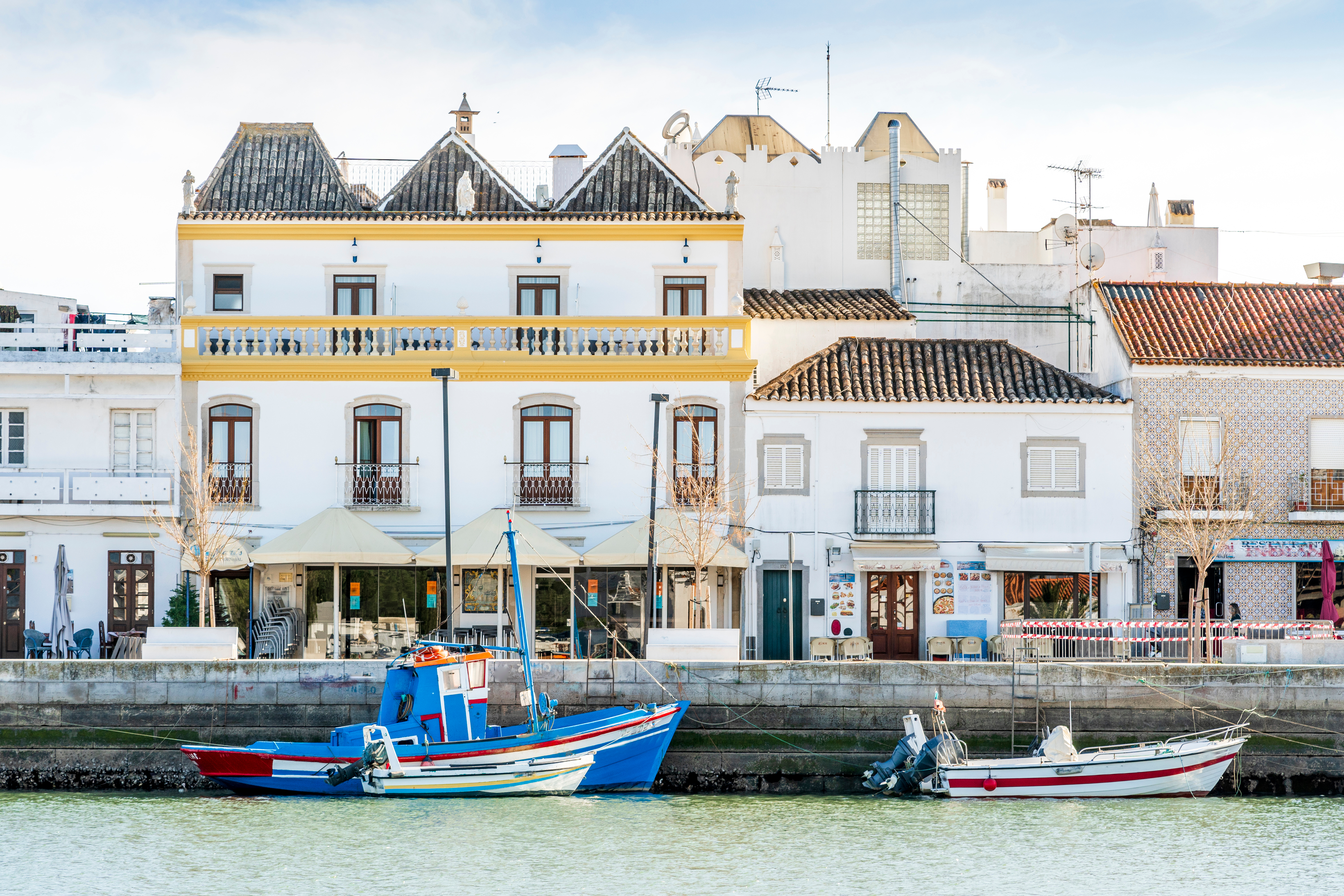 Charmerende hvide bygninger langs Gilao-floden i Tavira, en historisk by i Algarve med traditionel portugisisk arkitektur
