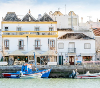 Charmerende hvide bygninger langs Gilao-floden i Tavira, en historisk by i Algarve med traditionel portugisisk arkitektur