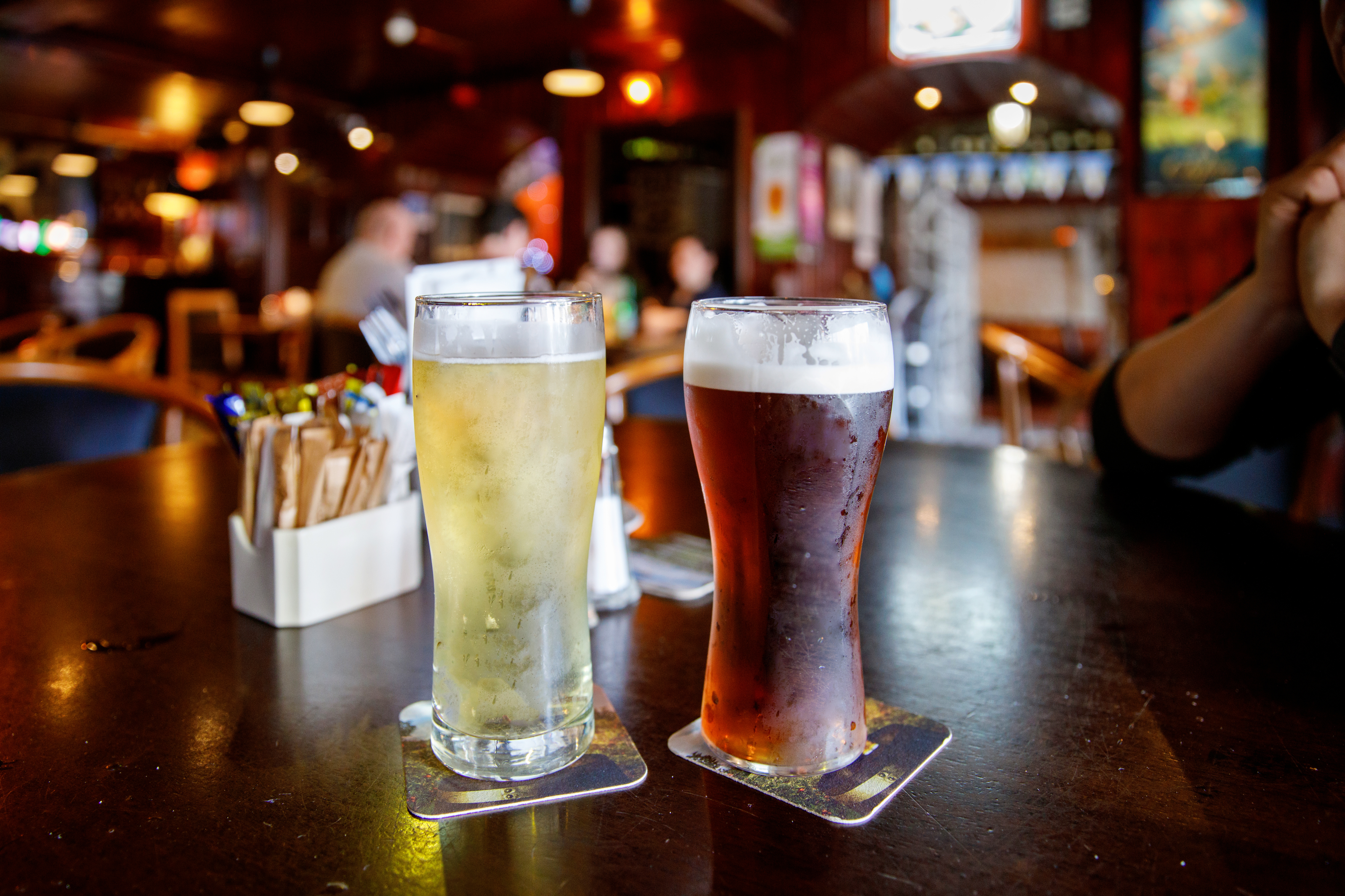 To øl på bardisken i det historiske Temple Bar-kvarter i Dublin, Irland – en lys cider og en mørk amber ale med skummende top