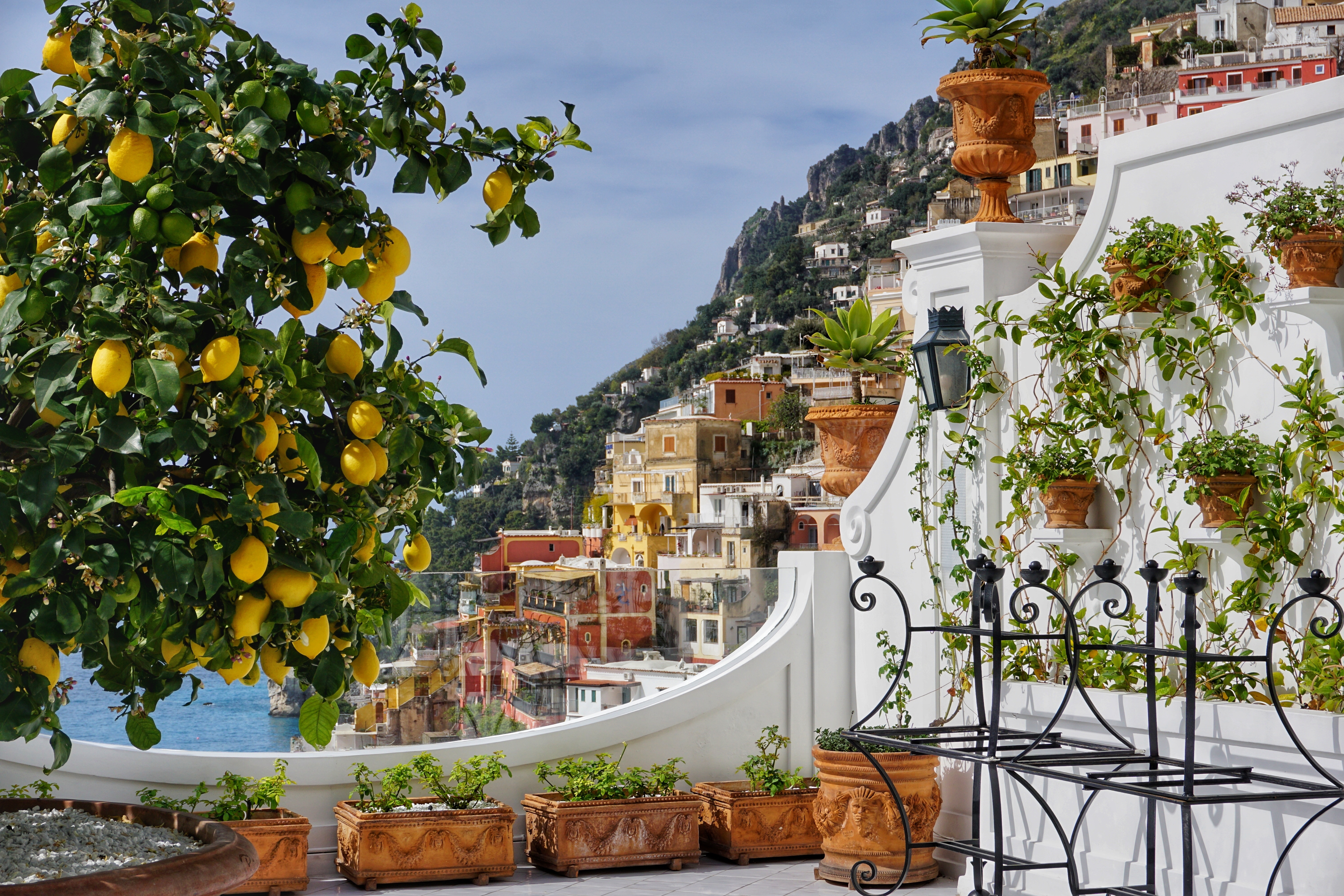 Smuk terrasse med citrontræ og krukker med udsigt over Positanos farverige bygninger og det blå Middelhav på Amalfikysten