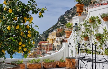 Smuk terrasse med citrontræ og krukker med udsigt over Positanos farverige bygninger og det blå Middelhav på Amalfikysten