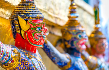 Traditionelle thailandske tempelvogtere med farverig mosaik dekoration i Bangkok tempel