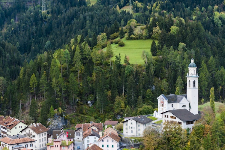 Idyllisk bjerglandsby Tiefencastel med traditionel kirke og arkitektur omgivet af de majestætiske alper i Graubünden, Schweiz