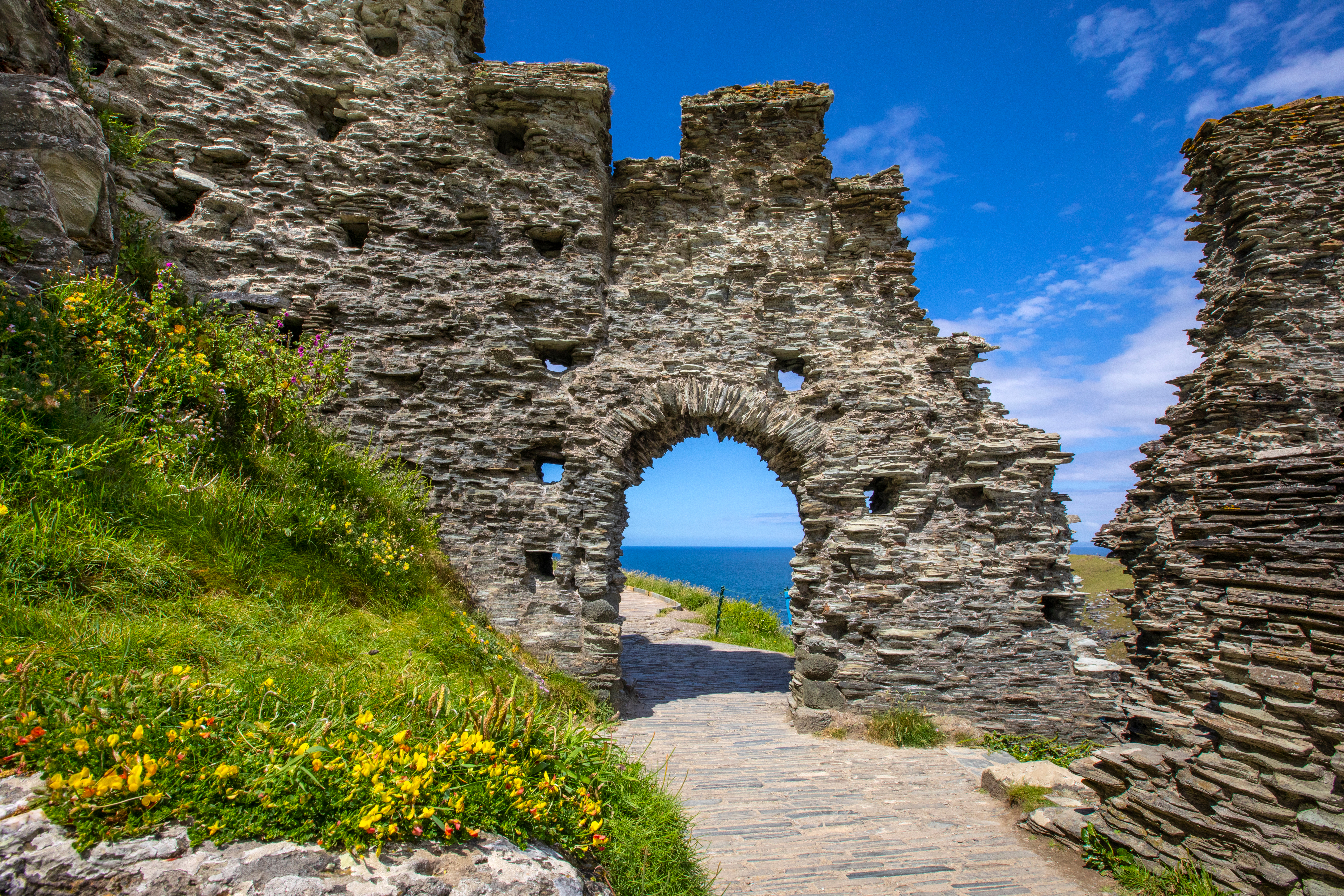 Historisk indgangsportal til Tintagel Castle i Cornwall, England, hvor Kong Arthur ifølge legenden blev født, med dramatisk kystlandskab