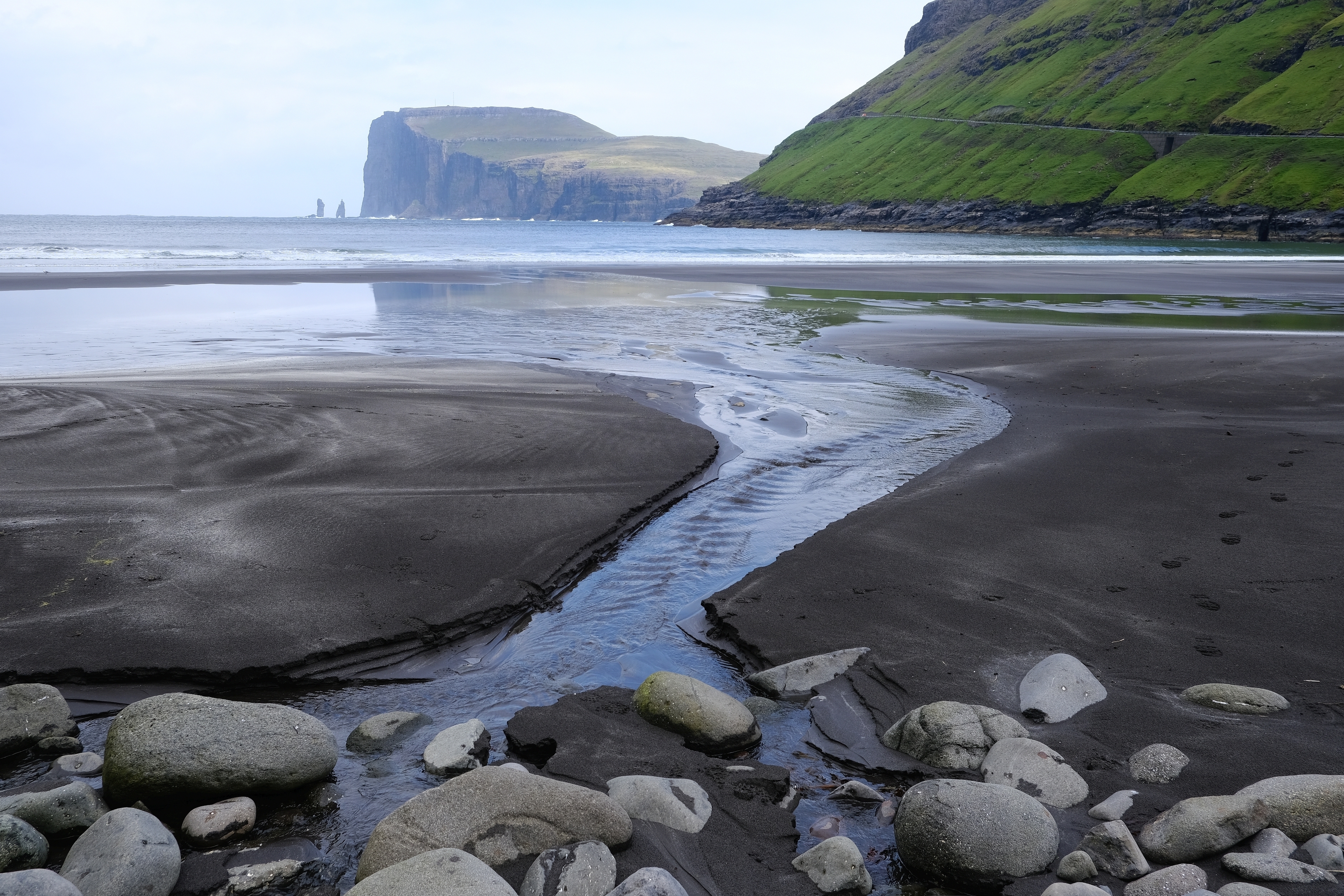Sort sandstrand ved Tjørnuvík med udsigt til klippeformationerne Risin og Kellingin på Færøernes største ø, Streymoy