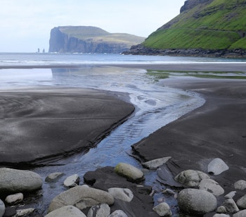 Sort sandstrand ved Tjørnuvík med udsigt til klippeformationerne Risin og Kellingin på Færøernes største ø, Streymoy