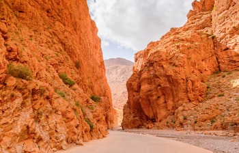 Imponerende røde klippeformationer i Todgha-kløften med smal sti mellem de stejle kløftvægge i Atlasbjergene nær Tinerhir, Marokko