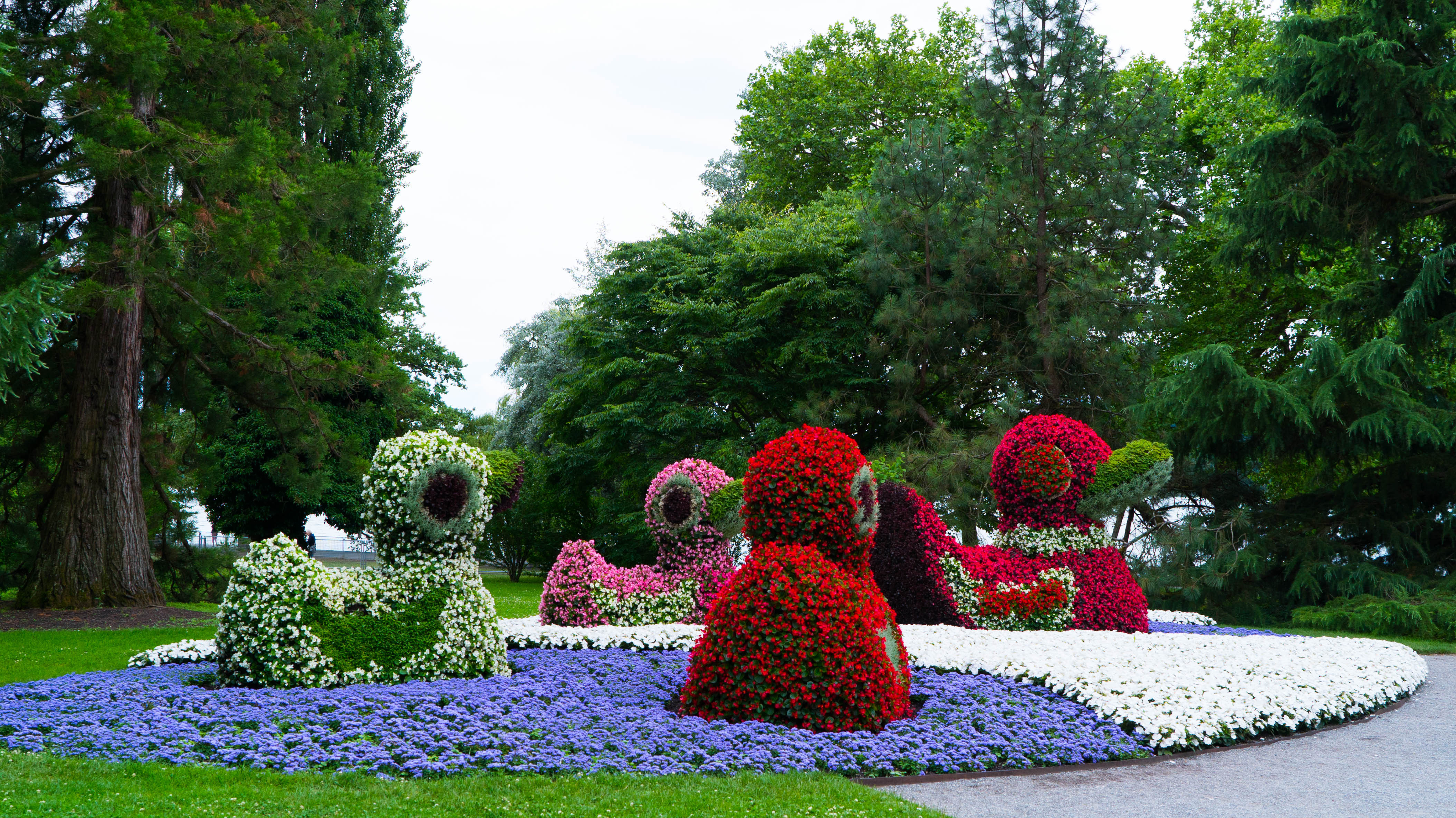 Farverige topiary haver med blomster skulpturer i smuk park