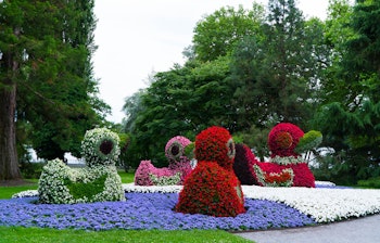 Farverige topiary haver med blomster skulpturer i smuk park