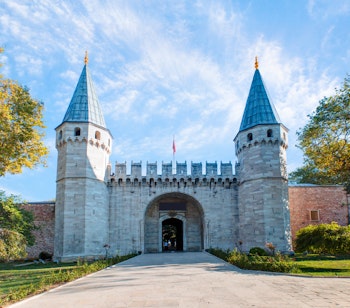 Den imponerende indgangsport til det historiske Topkapi-palads i Istanbul, Tyrkiet med blå himmel i baggrunden