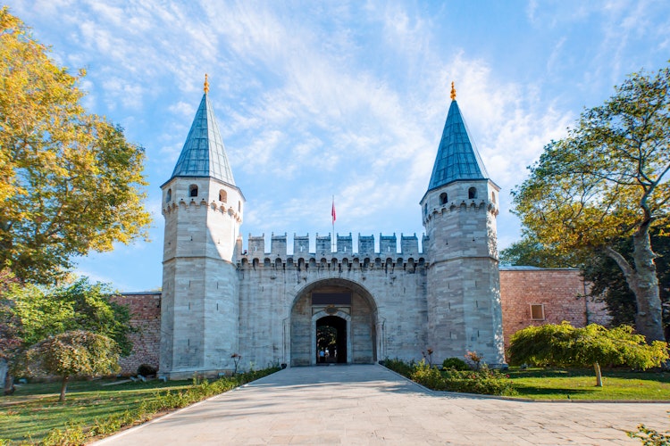 Den imponerende indgangsport til det historiske Topkapi-palads i Istanbul, Tyrkiet med blå himmel i baggrunden