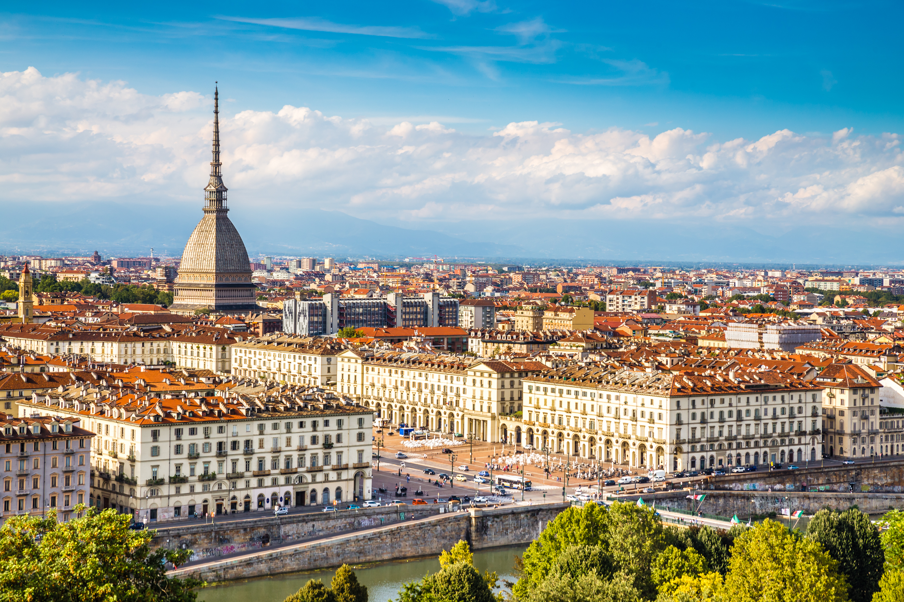 Panoramisk udsigt over Torino bycentrum med det ikoniske Mole Antonelliana tårn omgivet af bjerge under blå himmel i Piemonte, Italien