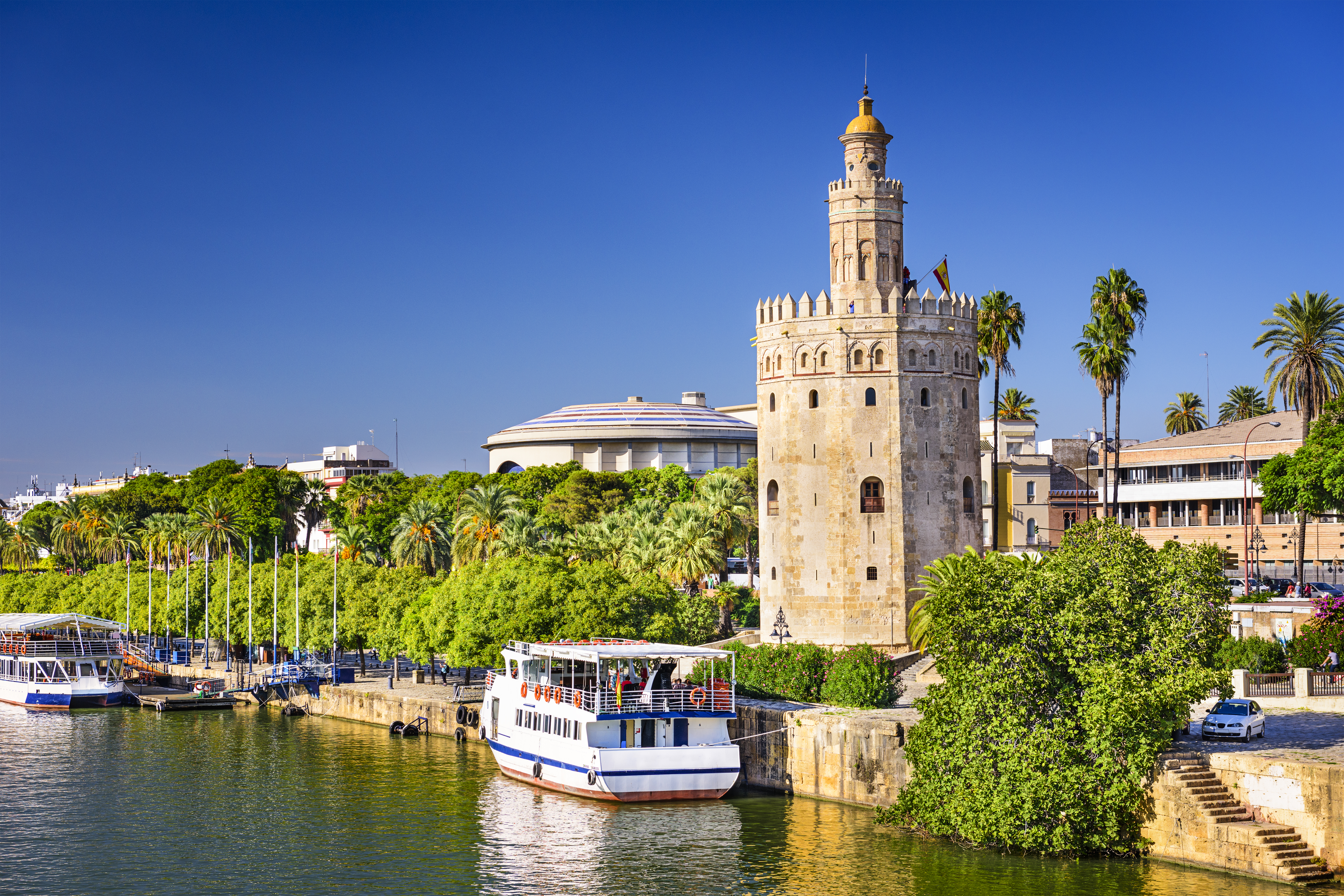 Torre del Oro det gyldne tårn ved Guadalquivir floden i Sevilla Spanien med turistbåde