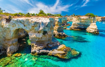 Malerisk udsigt over Torre Sant' Andrea med turkisblåt hav og dramatiske klippeformationer langs Salento-kysten i Puglia, Italien