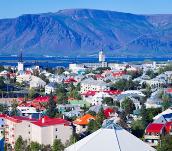 Luftfoto af Tórshavn, Færøernes charmerende hovedstad med den farverige havn og bjerglandskab i baggrunden