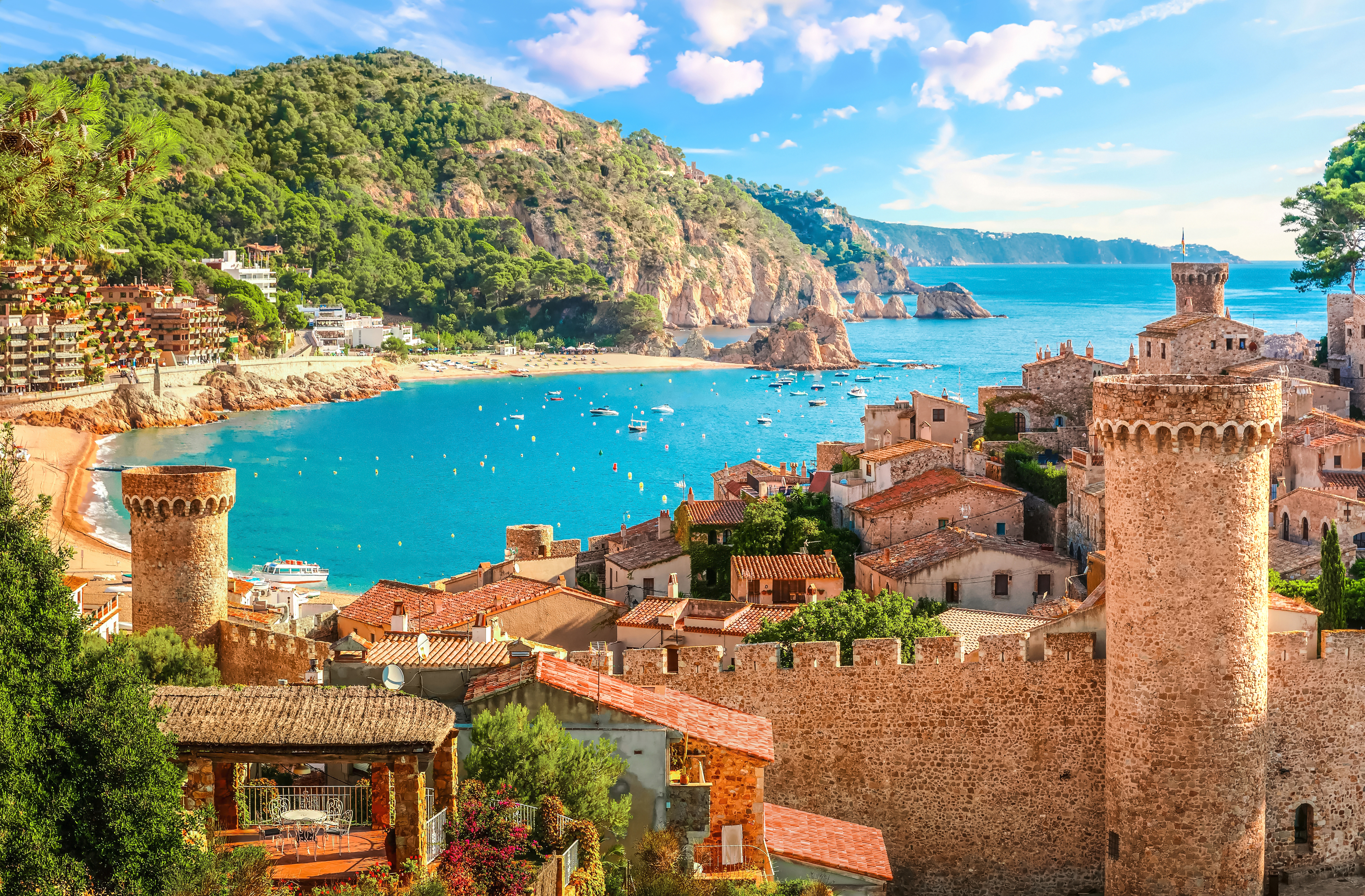 Betagende udsigt over Tossa de Mar med den historiske befæstede gamle bydel Vila Vella, der troner over Middelhavets azurblå vand og den gyldne strand