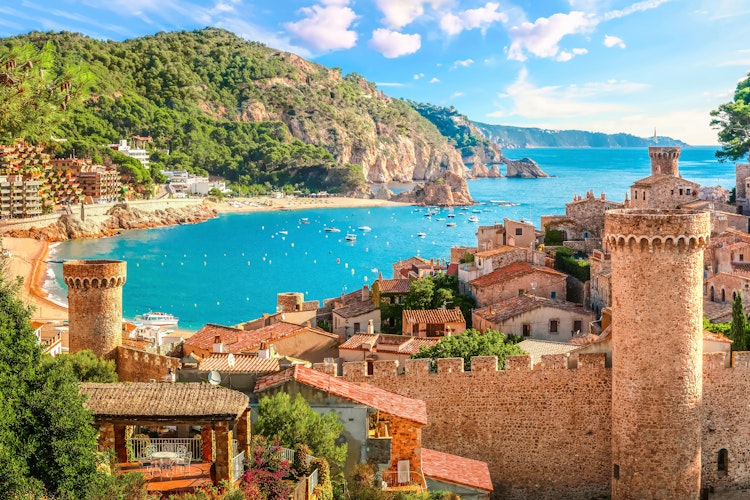 Betagende udsigt over Tossa de Mar med den historiske befæstede gamle bydel Vila Vella, der troner over Middelhavets azurblå vand og den gyldne strand