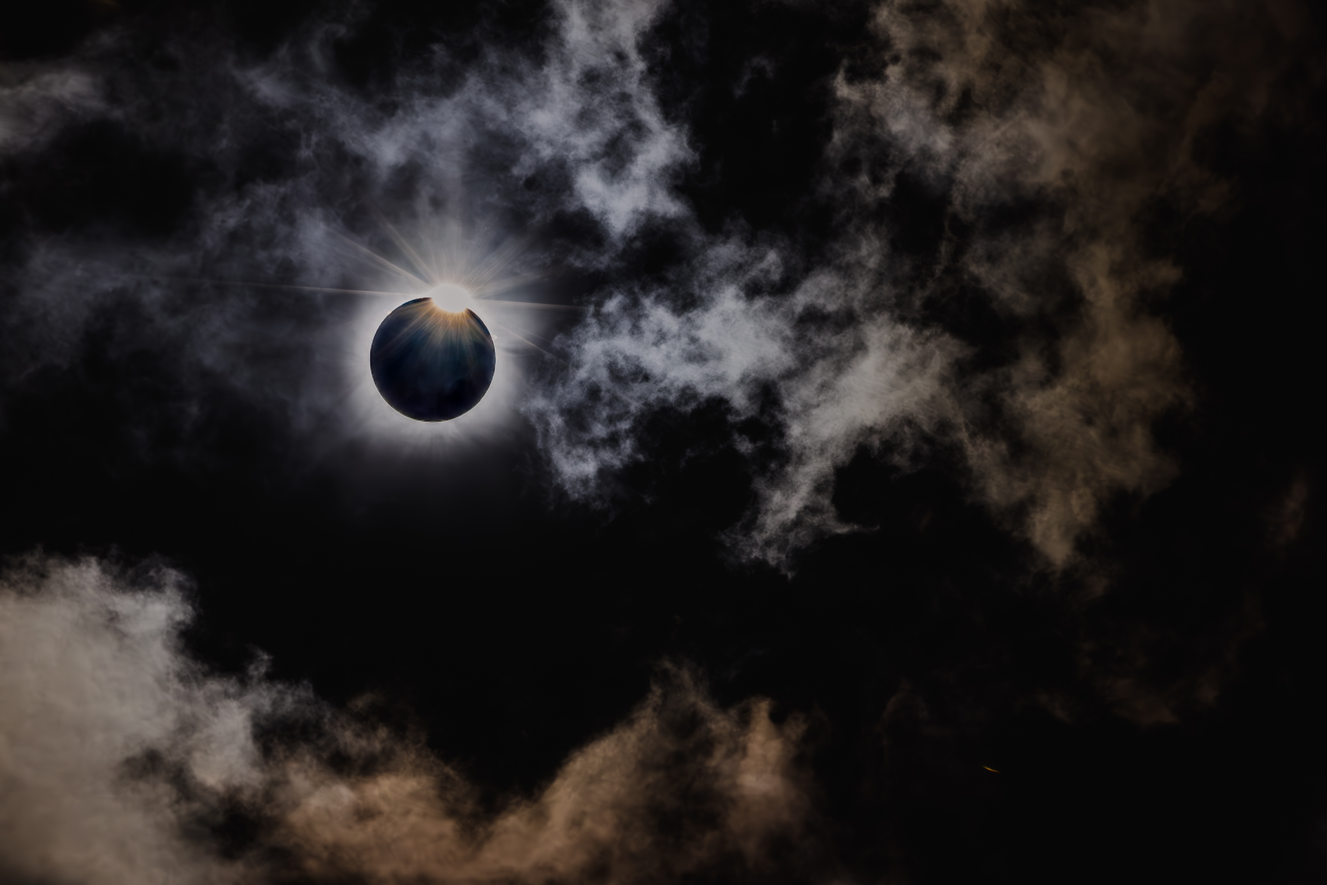 Total solformørkelse med synlig corona gennem dramatisk skydække under astronomisk fænomen