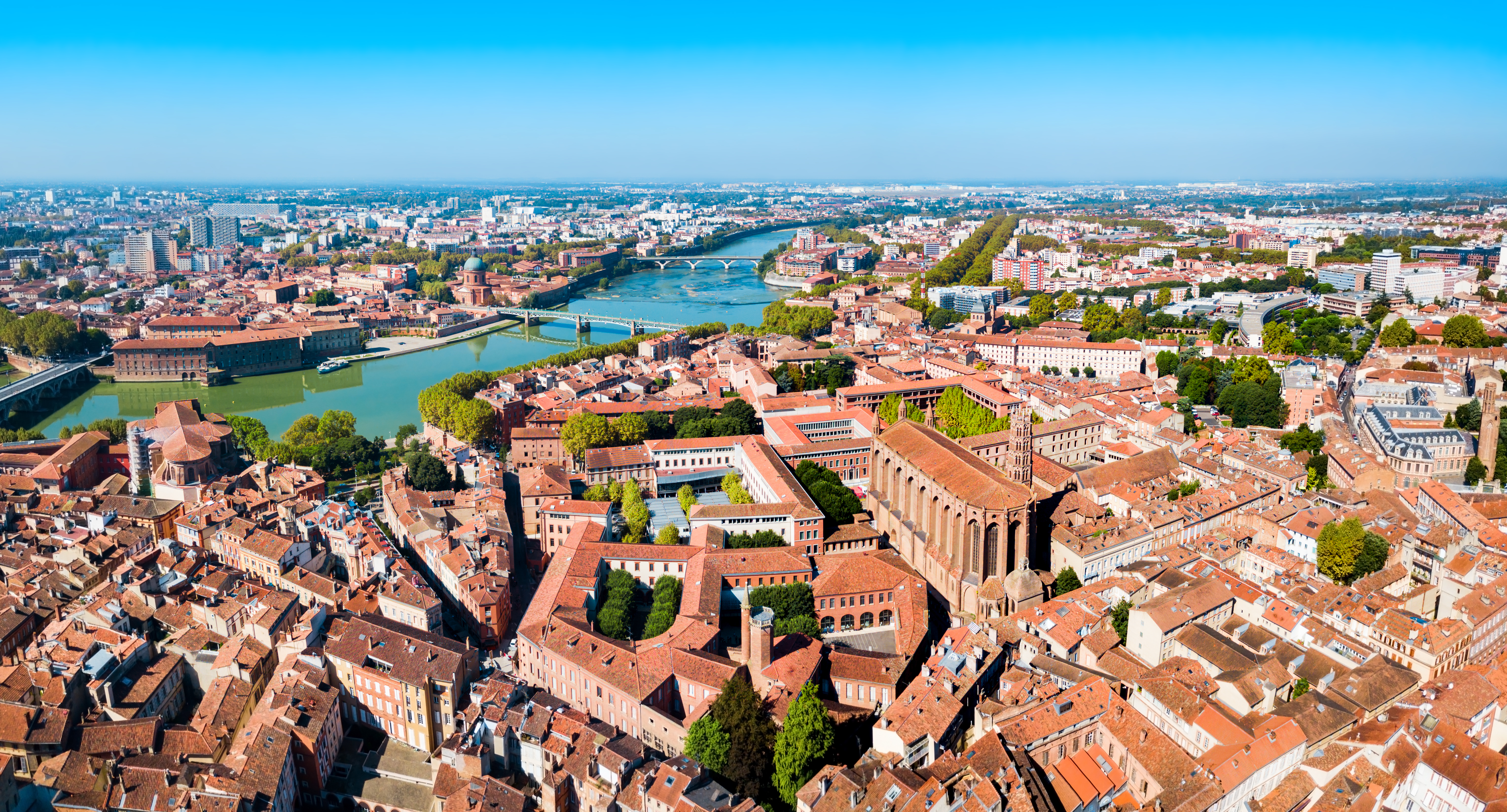 Luftpanorama over Toulouse med Garonne-floden der løber gennem den historiske bymidte med klassisk fransk arkitektur og broer i Occitanie-regionen