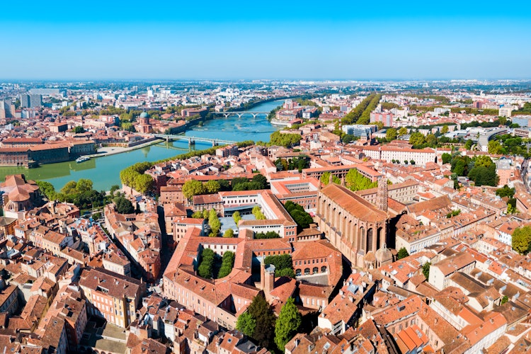 Luftpanorama over Toulouse med Garonne-floden der løber gennem den historiske bymidte med klassisk fransk arkitektur og broer i Occitanie-regionen