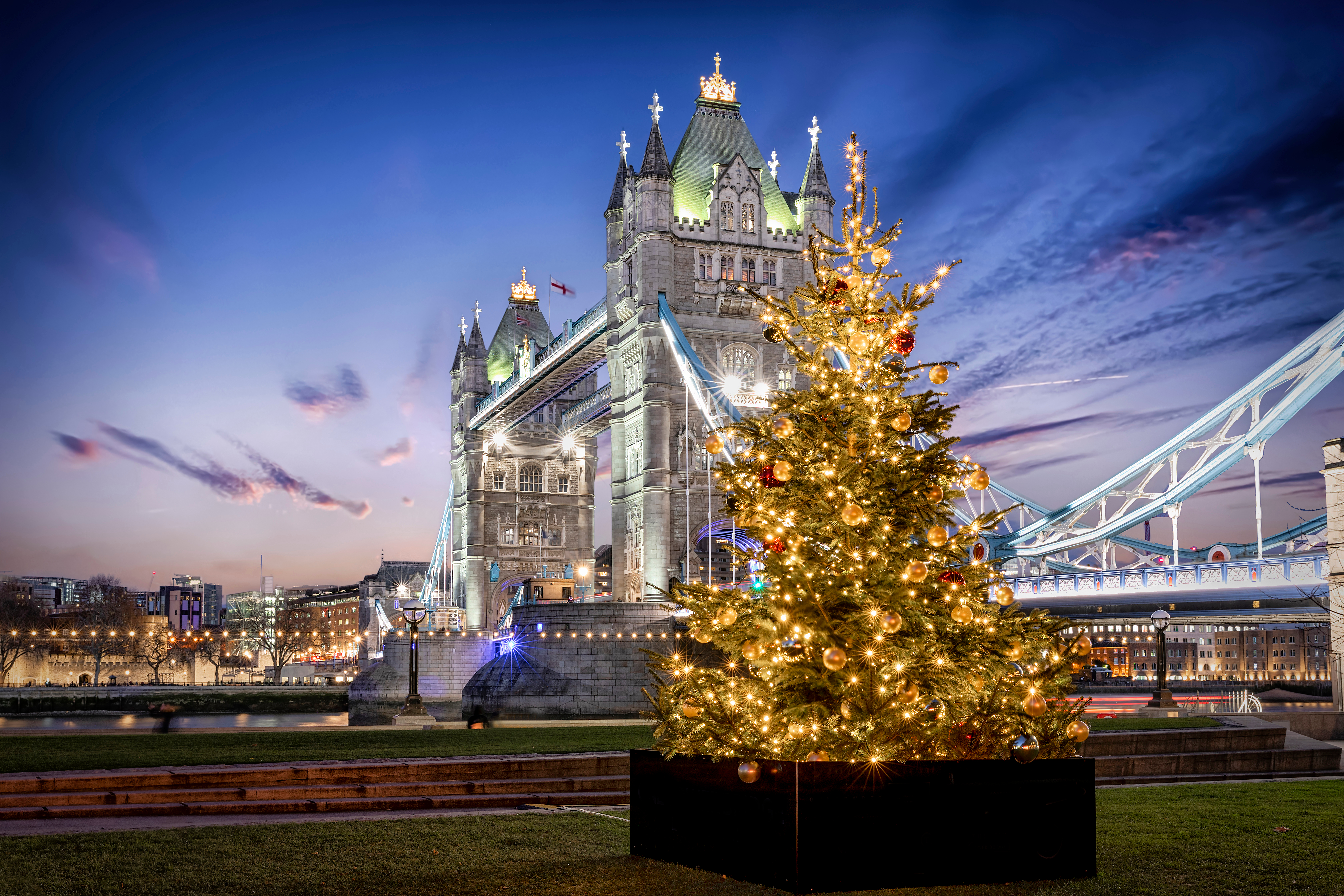Tower Bridge i London oplyst ved juletid med pyntet juletræ og festlige lys om aftenen