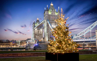 Tower Bridge i London oplyst ved juletid med pyntet juletræ og festlige lys om aftenen
