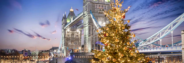 Tower Bridge i London oplyst ved juletid med pyntet juletræ og festlige lys om aftenen