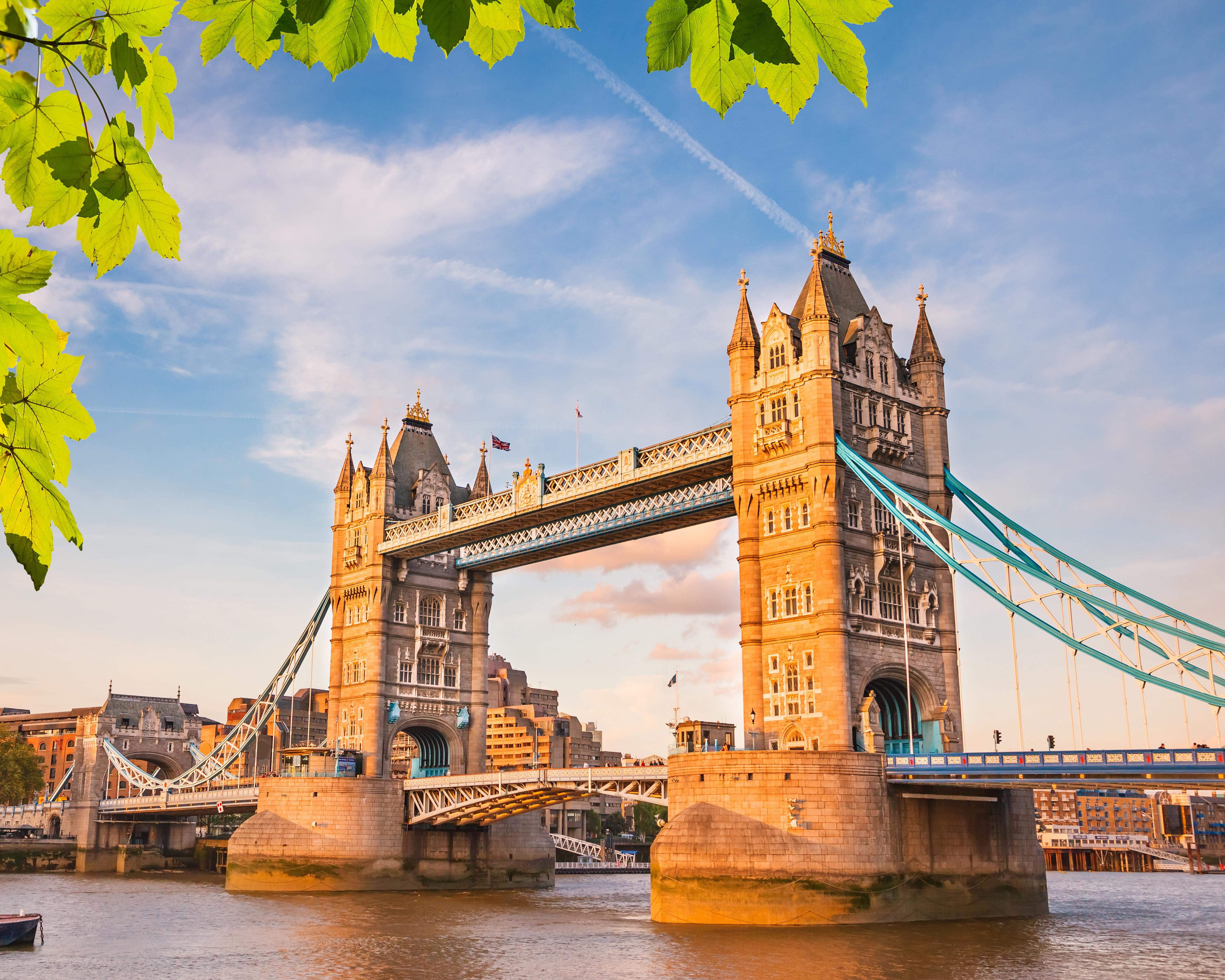 Det ikoniske Tower Bridge over Themsen i London på en solrig sommerdag med blå himmel og grønne træer