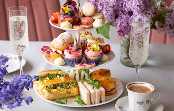 Elegant traditionel engelsk afternoon tea med sandwiches, scones og kager serveret på etagefad på det luksuriøse Reid's Palace hotel på Madeira