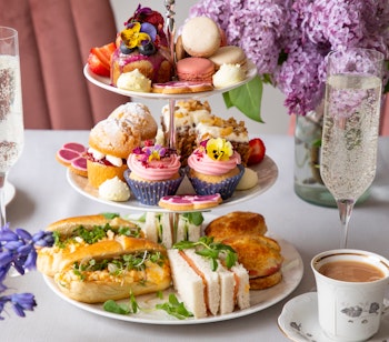 Elegant traditionel engelsk afternoon tea med sandwiches, scones og kager serveret på etagefad på det luksuriøse Reid's Palace hotel på Madeira