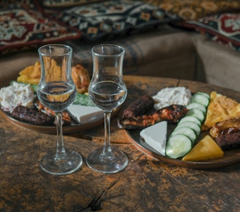Traditionel albansk madfad med lokale specialiteter og hjemmelavet raki serveret på restaurant i Albanien