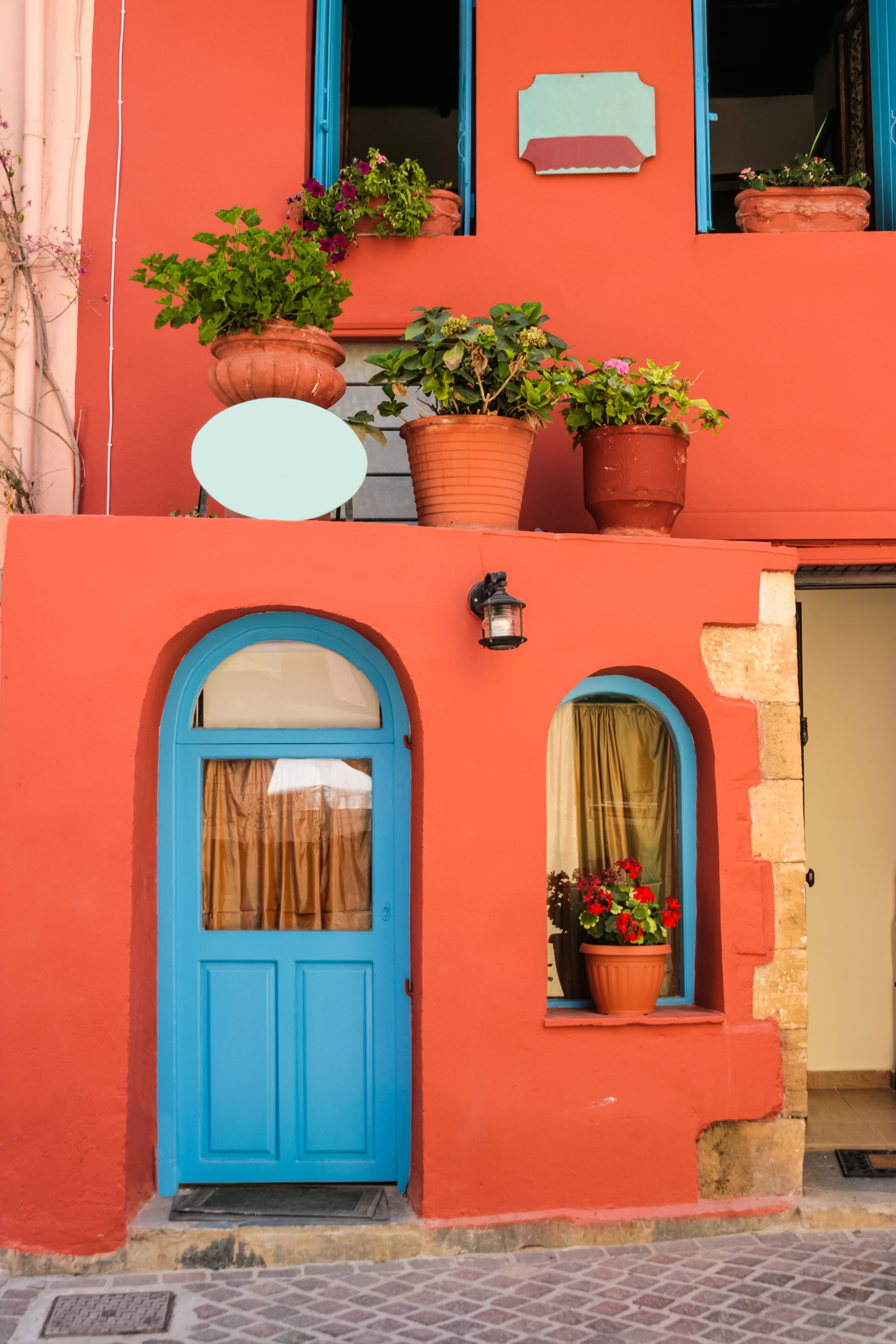 Idyllisk baggård med farverige blomster og traditionel arkitektur i den gamle bydel af Chania på Kreta, Grækenland