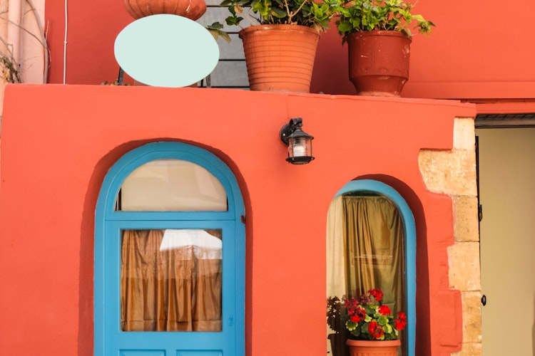 Idyllisk baggård med farverige blomster og traditionel arkitektur i den gamle bydel af Chania på Kreta, Grækenland