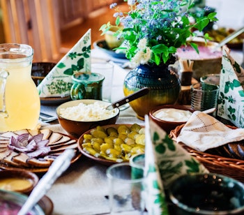 Autentisk baltisk frokostbord med traditionelle lettiske retter serveret i rustikke lerfade og træskåle