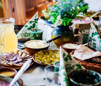 Autentisk baltisk frokostbord med traditionelle lettiske retter serveret i rustikke lerfade og træskåle
