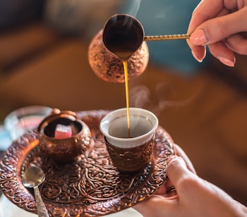 Autentisk bosnisk kaffetradition i Sarajevos historiske Baščaršija-kvarter, hvor kaffe hældes fra kobber džezva til traditionel kop