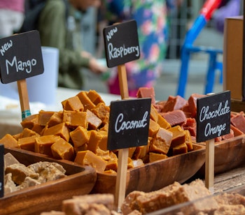 Farverig udstilling af traditionel britisk fudge med mango, hindbær og kokos på Borough Market i London