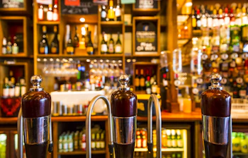 Traditionel britisk pub med ølhaner og flasker i London bar
