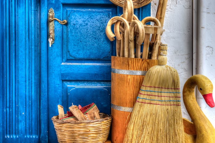 Charmerende traditionel butiksfacade med lokale varer på den græske ø Hydra, med karakteristisk blå dør og hvidkalkede mure